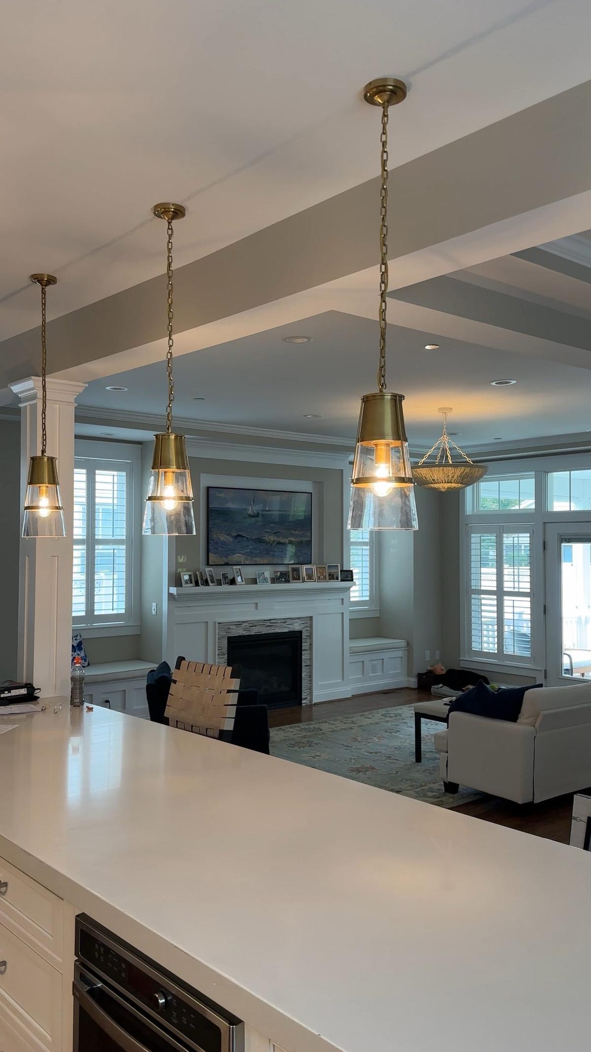 Three brass pendant lights installed over kitchen island