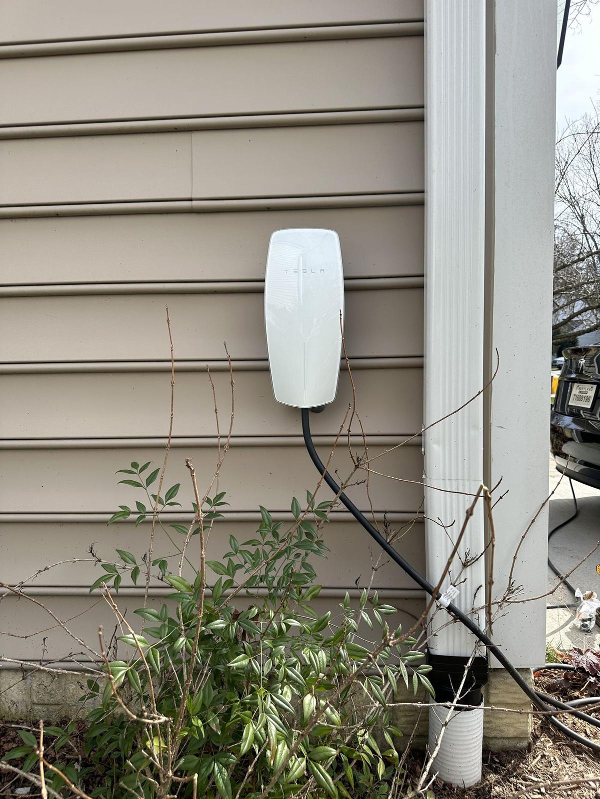 Tesla Wall Connector EV charger installed on the exterior wall of a home